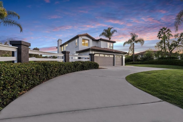 mediterranean / spanish home with a yard and a garage