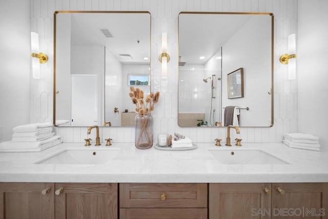 bathroom featuring a shower with shower door and vanity