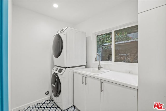 washroom with stacked washer and dryer, sink, and cabinets