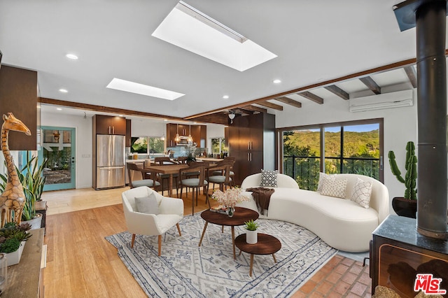 living room featuring a skylight, a healthy amount of sunlight, beam ceiling, and an AC wall unit