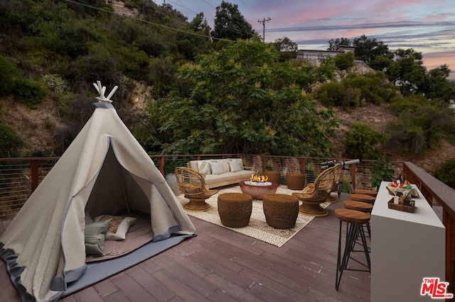 deck at dusk with outdoor lounge area