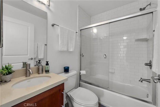 full bathroom with toilet, vanity, and bath / shower combo with glass door