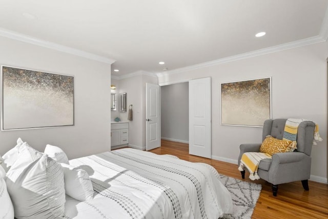 bedroom with crown molding, connected bathroom, and light wood-type flooring