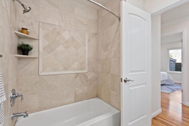 bathroom with tiled shower / bath combo and hardwood / wood-style floors