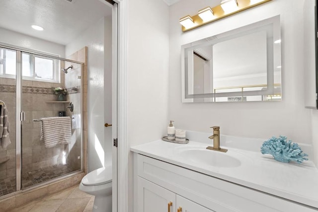 bathroom featuring tile patterned flooring, vanity, an enclosed shower, and toilet