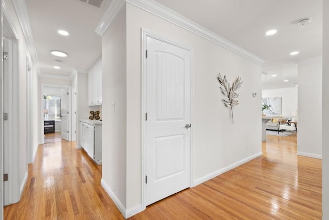 hallway with light hardwood / wood-style flooring and ornamental molding