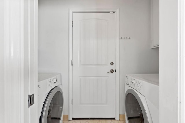 laundry area featuring light tile patterned floors and washing machine and clothes dryer