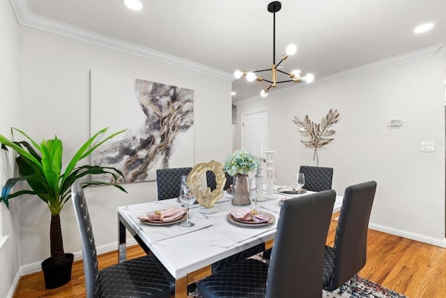 dining area featuring an inviting chandelier, ornamental molding, and wood-type flooring