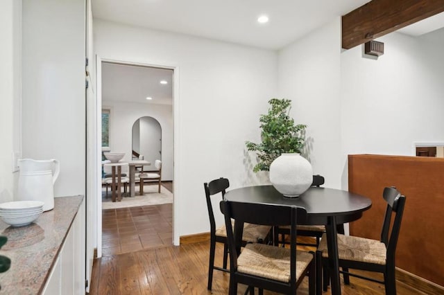 dining area with light hardwood / wood-style floors and beamed ceiling