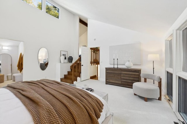 carpeted bedroom with high vaulted ceiling