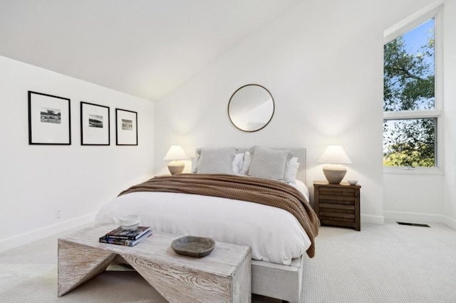 bedroom with lofted ceiling and light carpet