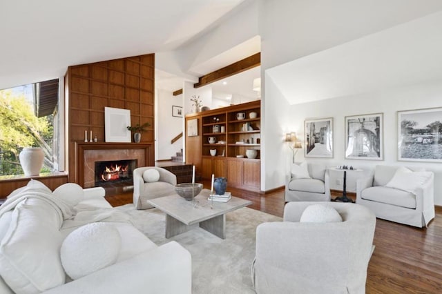 living room featuring dark wood-type flooring, lofted ceiling, and a premium fireplace