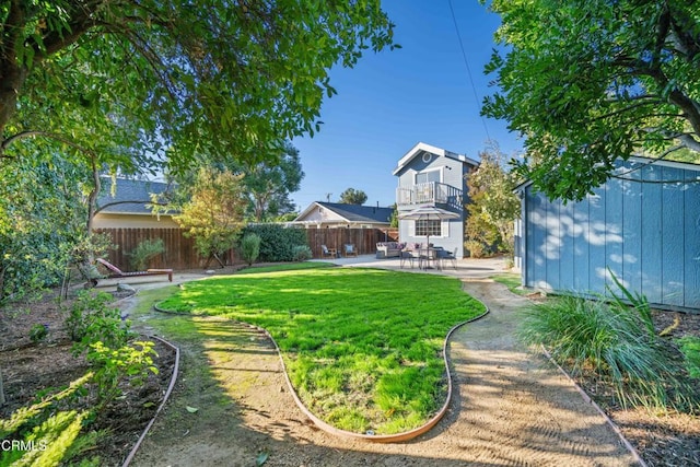 view of yard with a balcony and a patio