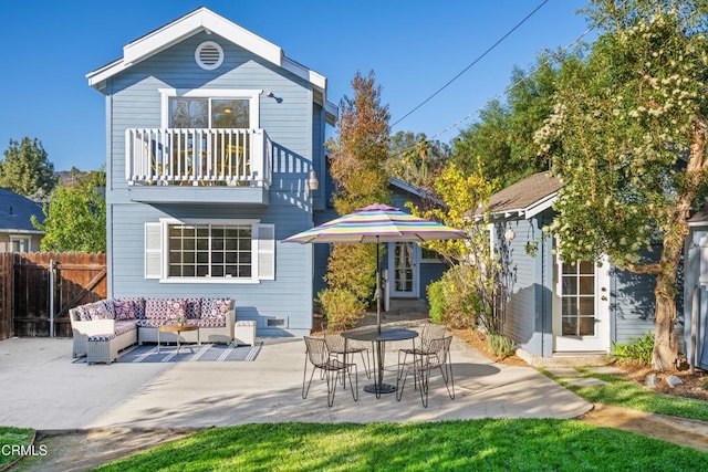 rear view of house with outdoor lounge area, a balcony, and a patio