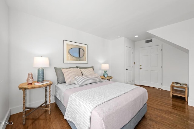 bedroom with dark hardwood / wood-style flooring and a closet