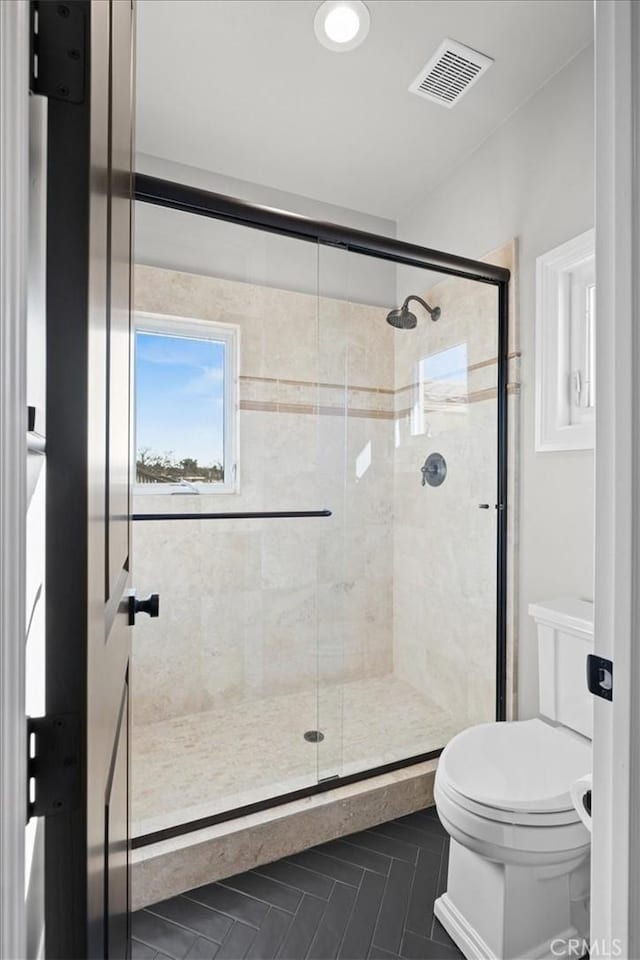 bathroom with walk in shower and toilet