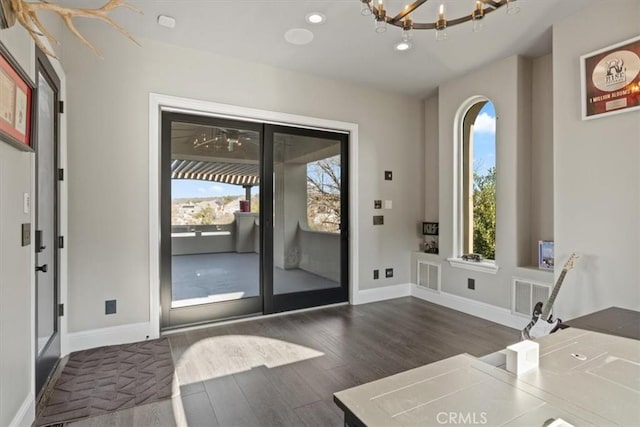 entryway featuring dark hardwood / wood-style flooring and a chandelier