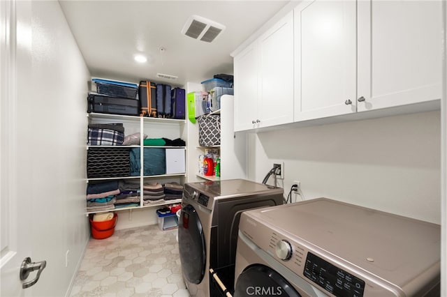 laundry area with washing machine and dryer and cabinets