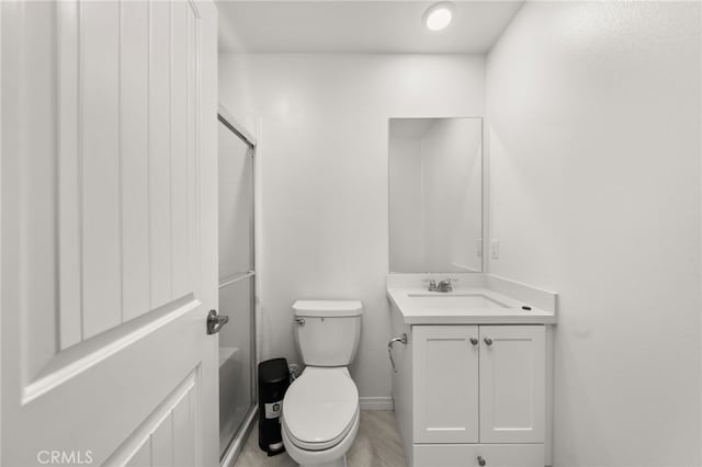 bathroom featuring toilet, vanity, and walk in shower