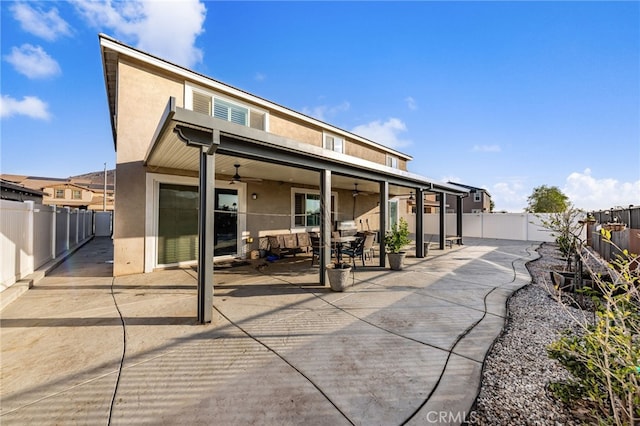 back of property featuring ceiling fan and a patio