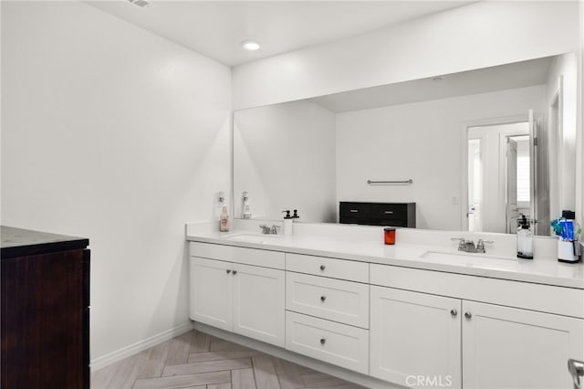 bathroom with vanity and parquet floors