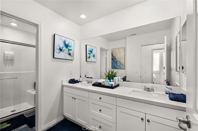 bathroom with a shower with door and vanity