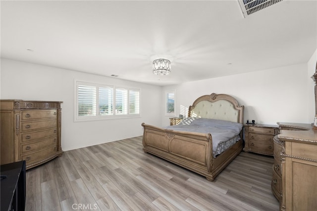 bedroom featuring a chandelier and light hardwood / wood-style floors