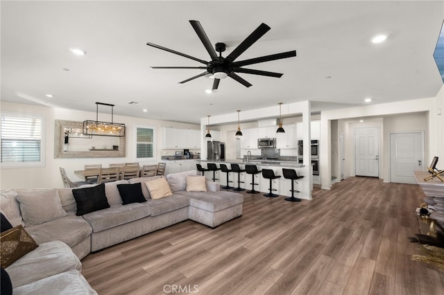 living room featuring ceiling fan, a healthy amount of sunlight, sink, and hardwood / wood-style flooring