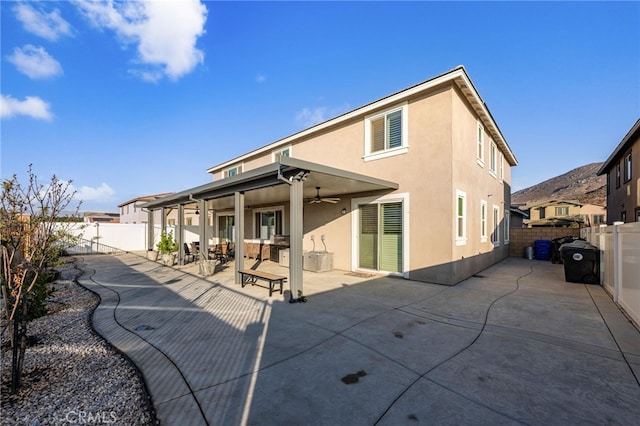 back of property featuring ceiling fan and a patio