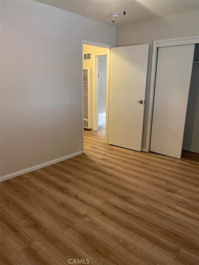 unfurnished bedroom with hardwood / wood-style floors and a closet