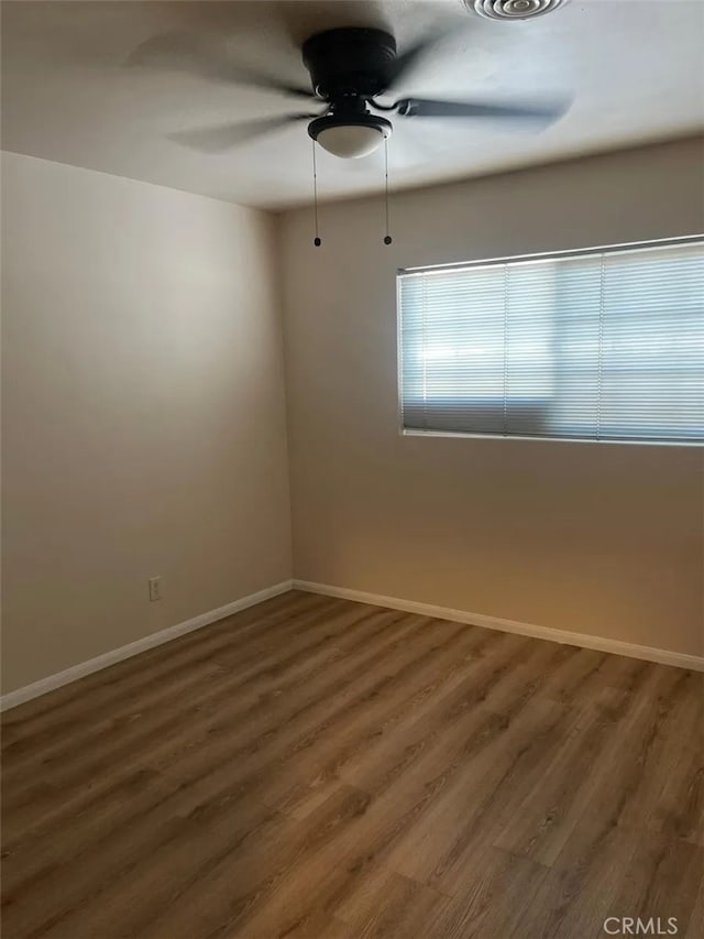 spare room featuring dark wood-type flooring and ceiling fan