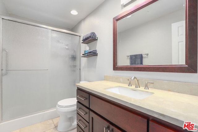 bathroom featuring an enclosed shower, vanity, toilet, and tile patterned flooring