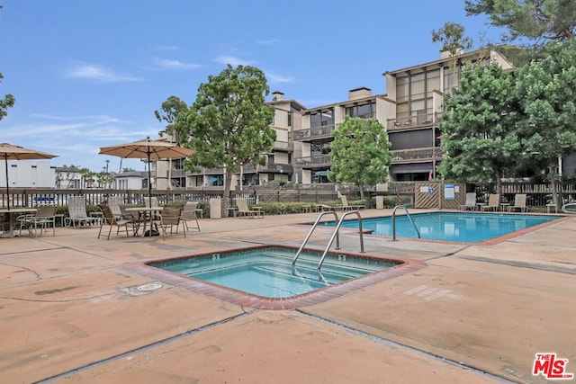 view of pool featuring a hot tub and a patio area