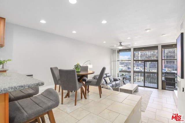 dining area with ceiling fan, light tile patterned flooring, and floor to ceiling windows