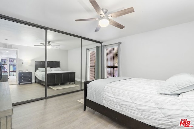 bedroom with a closet, light hardwood / wood-style flooring, and ceiling fan