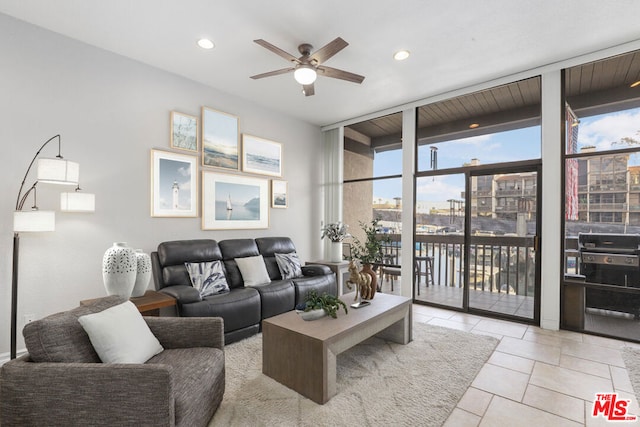 living room featuring ceiling fan, floor to ceiling windows, and light tile patterned flooring