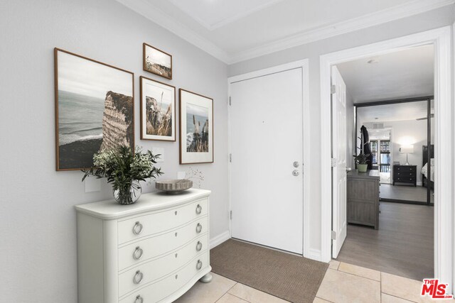 tiled entryway featuring ornamental molding