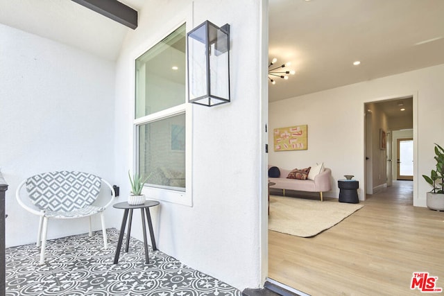 interior space featuring an inviting chandelier, hardwood / wood-style floors, and vaulted ceiling with beams