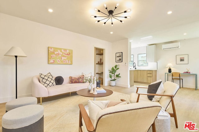 living room with an AC wall unit, light hardwood / wood-style floors, and a notable chandelier