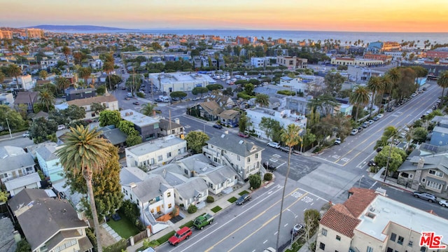 aerial view at dusk featuring a water view