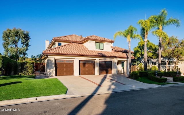 mediterranean / spanish house with a garage and a front yard