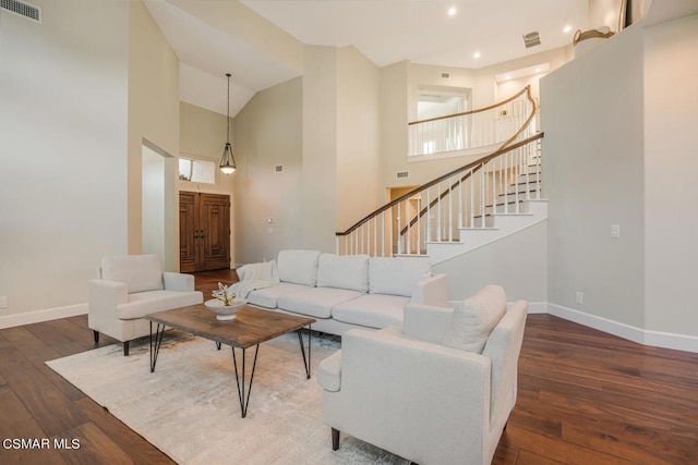 living room with dark wood-type flooring and high vaulted ceiling