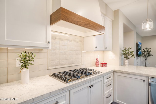 kitchen featuring pendant lighting, custom exhaust hood, decorative backsplash, stainless steel gas cooktop, and white cabinets