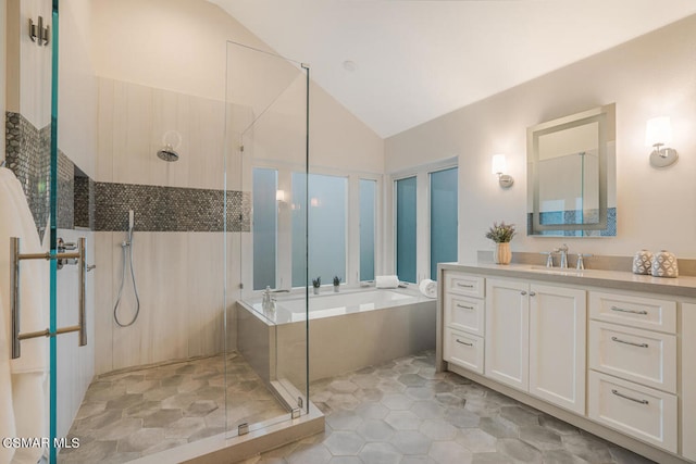 bathroom featuring shower with separate bathtub, vanity, and vaulted ceiling