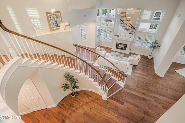 stairs featuring wood-type flooring and a towering ceiling