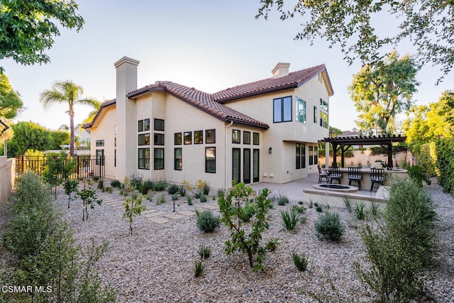 rear view of property with exterior bar, an outdoor kitchen, and a patio