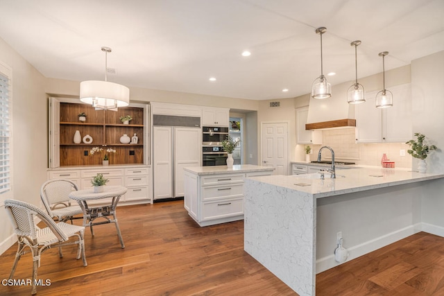 kitchen featuring hanging light fixtures, white cabinets, and hardwood / wood-style floors