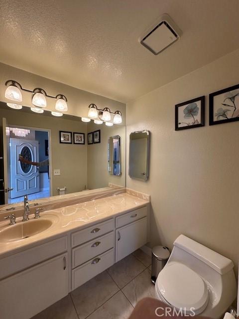 bathroom featuring tile patterned floors, vanity, and toilet