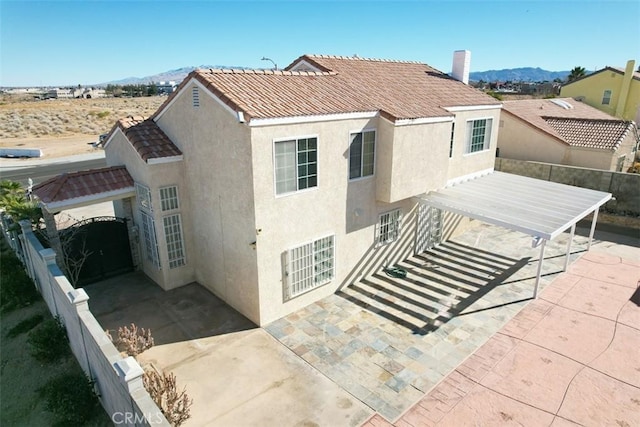 back of house featuring a mountain view and a patio area