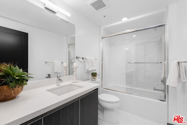 full bathroom with combined bath / shower with glass door, vanity, and toilet